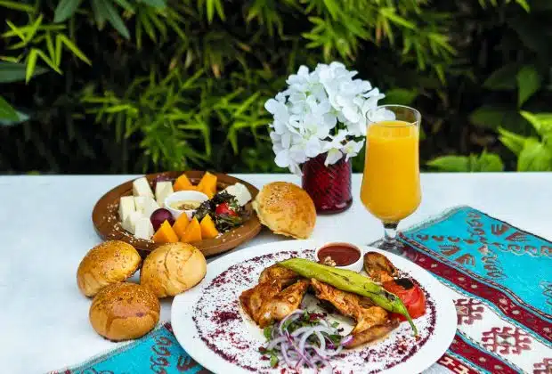 bread with vegetable on white ceramic plate beside drinking glass with yellow liquid